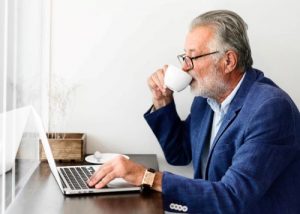 Gentleman at laptop reviewing his pension